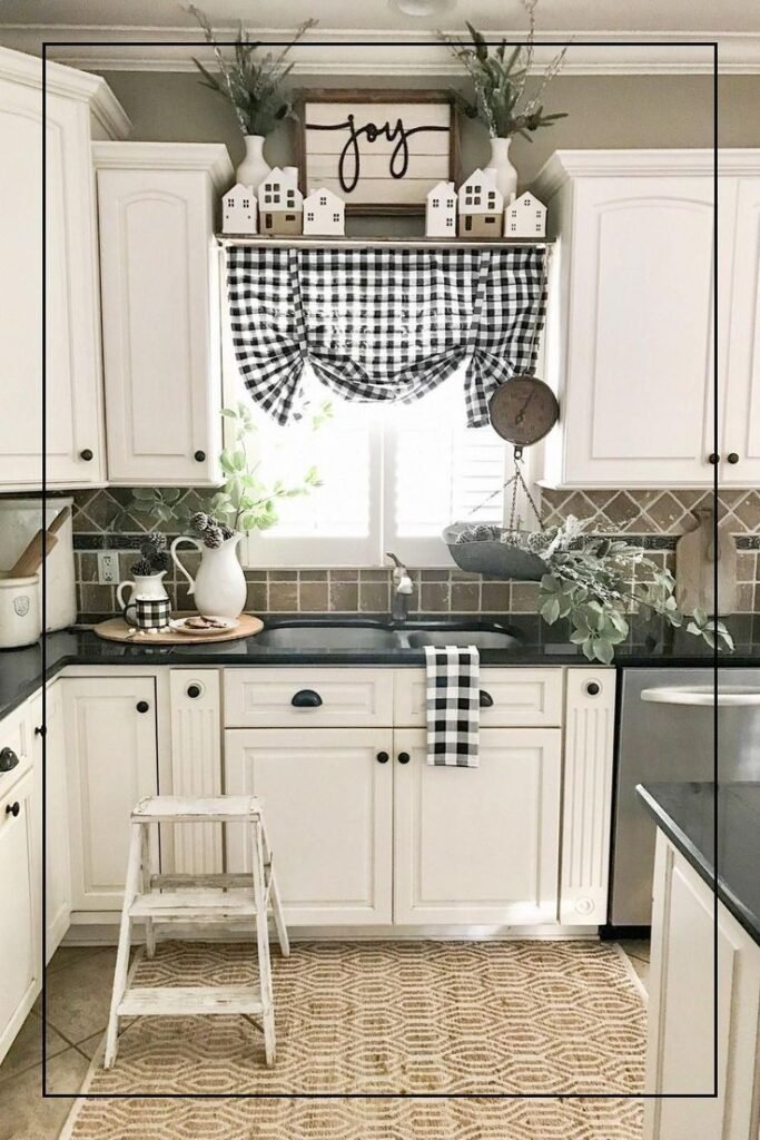 Black and white buffalo check styling above kitchen cabinets with white pitchers, greenery and a Joy sign