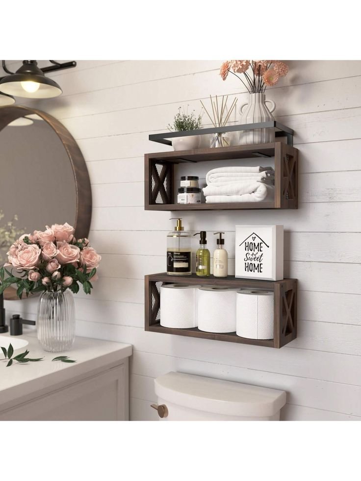 Rustic wood bathroom shelf styled with flowers, folded towels, soap bottles and a home sweet home sign above a toilet