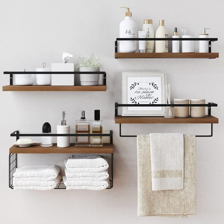 Rustic wood bathroom shelf with neatly rolled towels, apothecary jars and a diffuser above a toilet