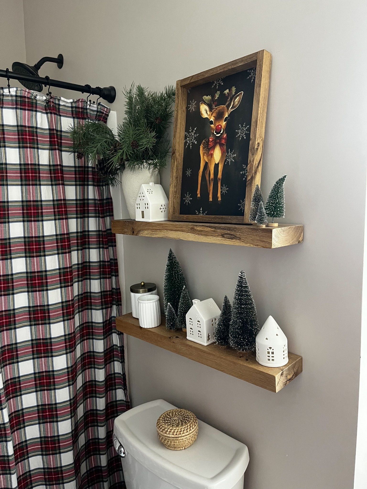 Floating shelves with a reindeer art print and small white Christmas houses