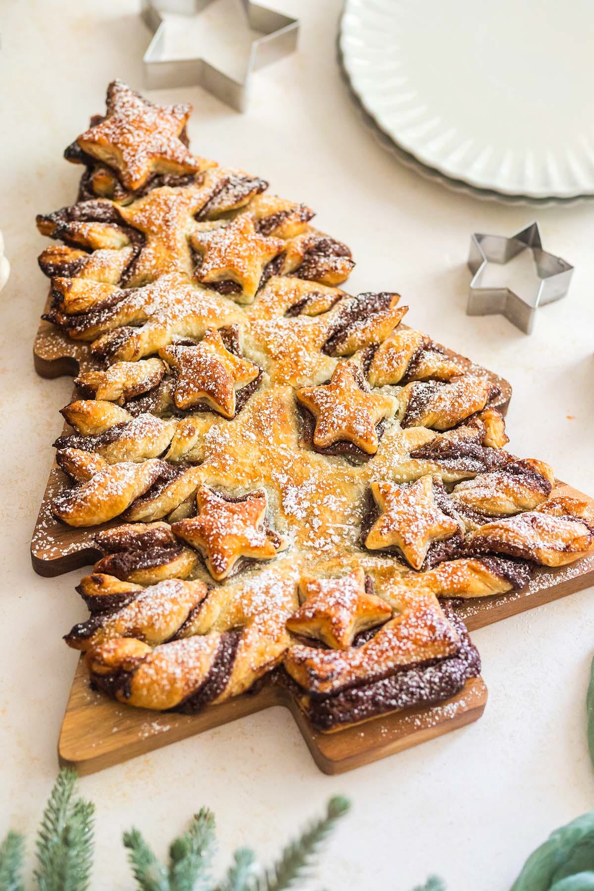 Puff pastry shaped into a Christmas tree with Nutella swirls and star cutouts