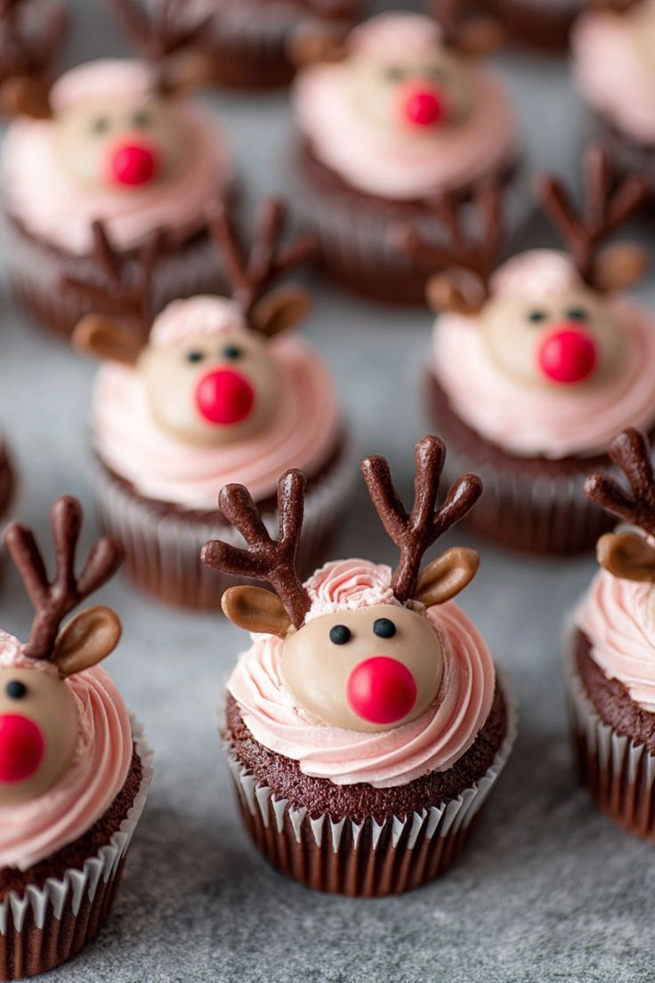 Chocolate cupcakes decorated as reindeer faces with candy noses and chocolate antlers
