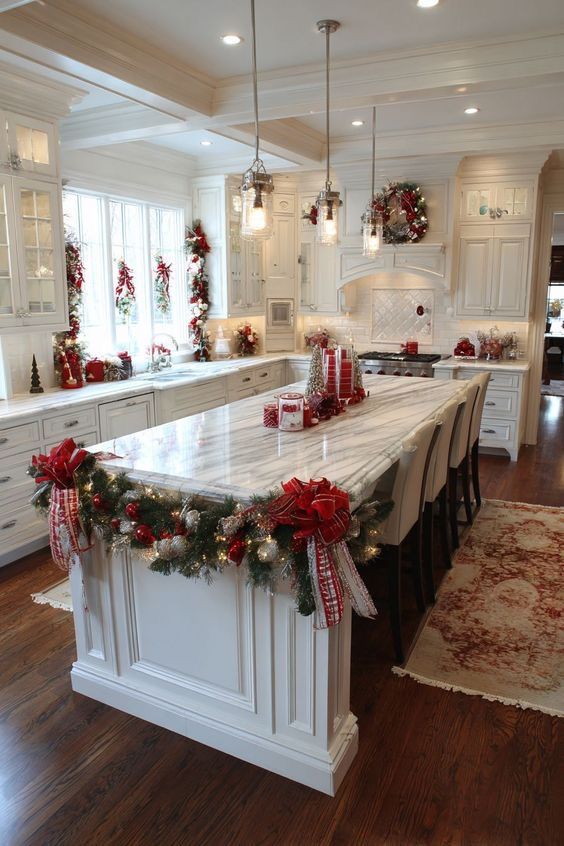 Long white kitchen island with a thick garland and large red plaid bows along its edge