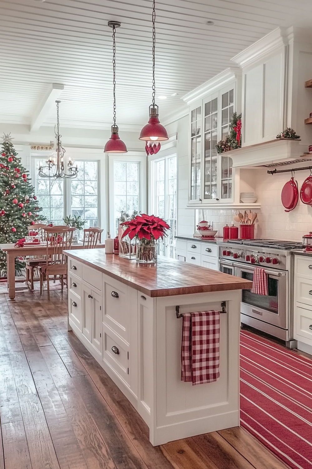 Red and white farmhouse kitchen with red pendant lights, a poinsettia on the island and a gingham towel on the rail