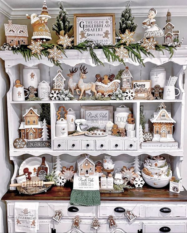 A white hutch styled as a gingerbread bakery with cookie jars and signs