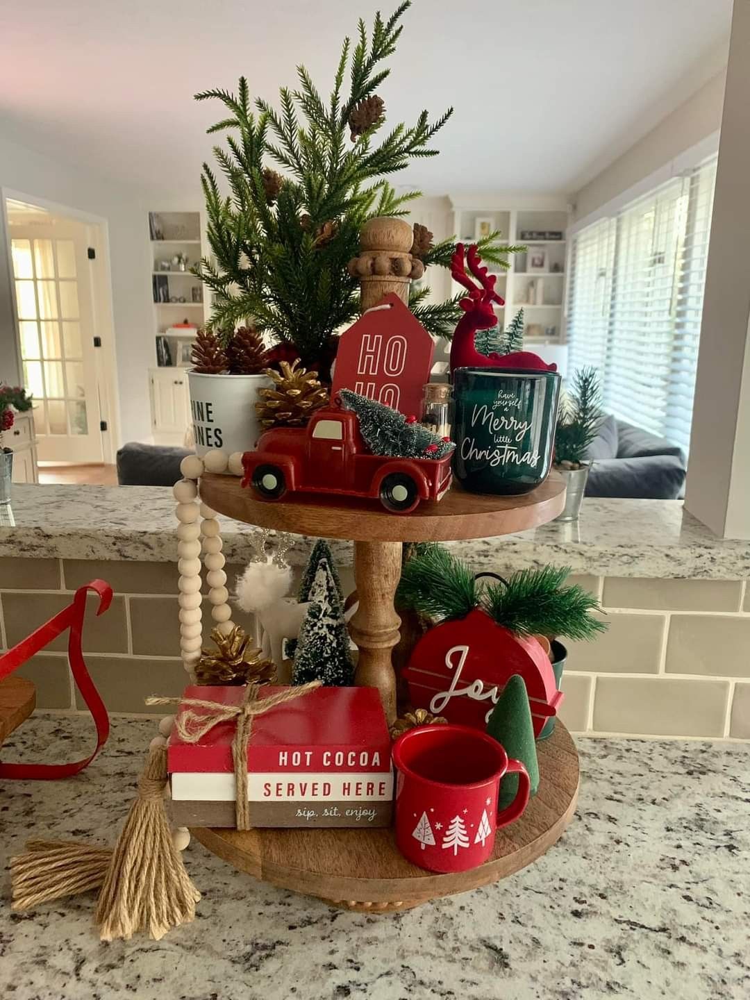 Two-tier wood tray with a red toy truck, a reindeer mug, and wood bead garland