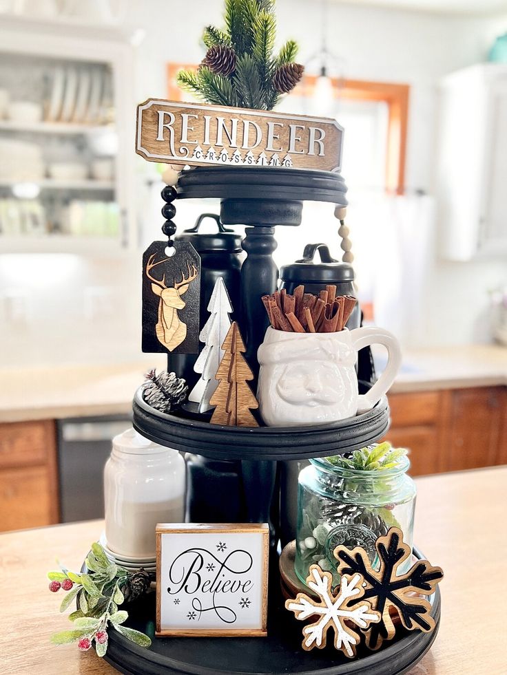 Black tiered tray with a Reindeer Crossing wood sign and cinnamon sticks