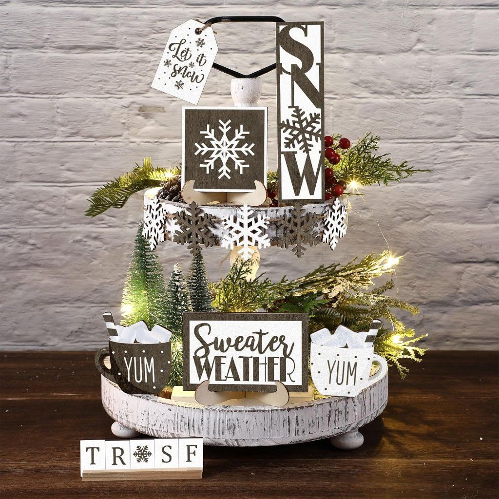 Tiered tray with black and white Snow and Sweater Weather wood signs and string lights