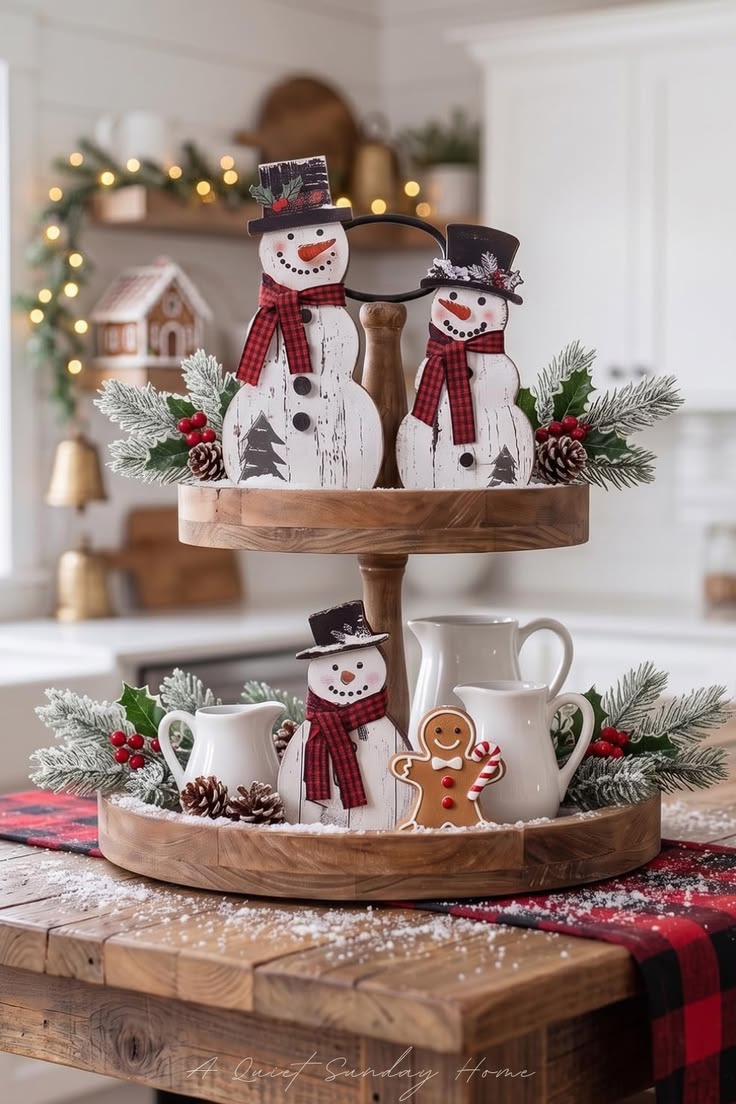 Tiered tray with two painted wood snowman cutouts wearing plaid scarves