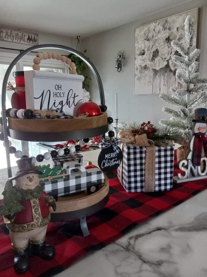 Tiered tray filled with buffalo plaid ball ornaments and pinecones