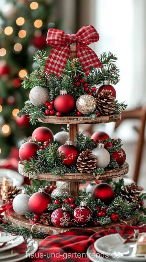 Three-tier tray filled with red white and gold ball ornaments and a plaid bow
