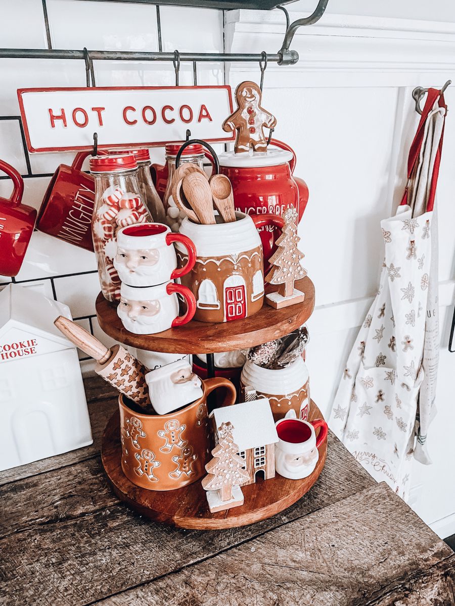 Tiered tray with a Hot Cocoa sign, Santa mugs, and a gingerbread house utensil holder