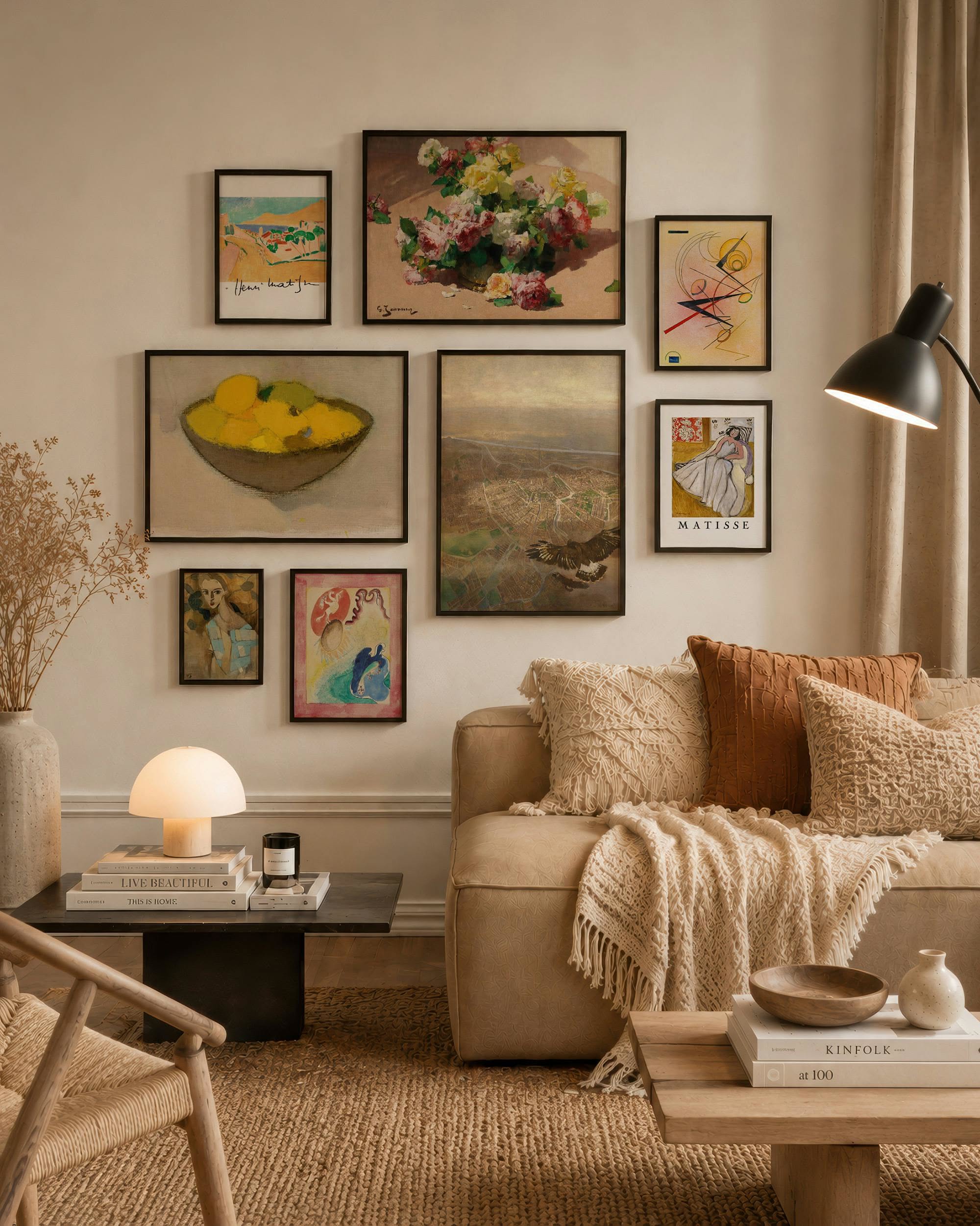 Gallery wall of framed vintage art prints above a beige sofa with textured pillows and a mushroom lamp