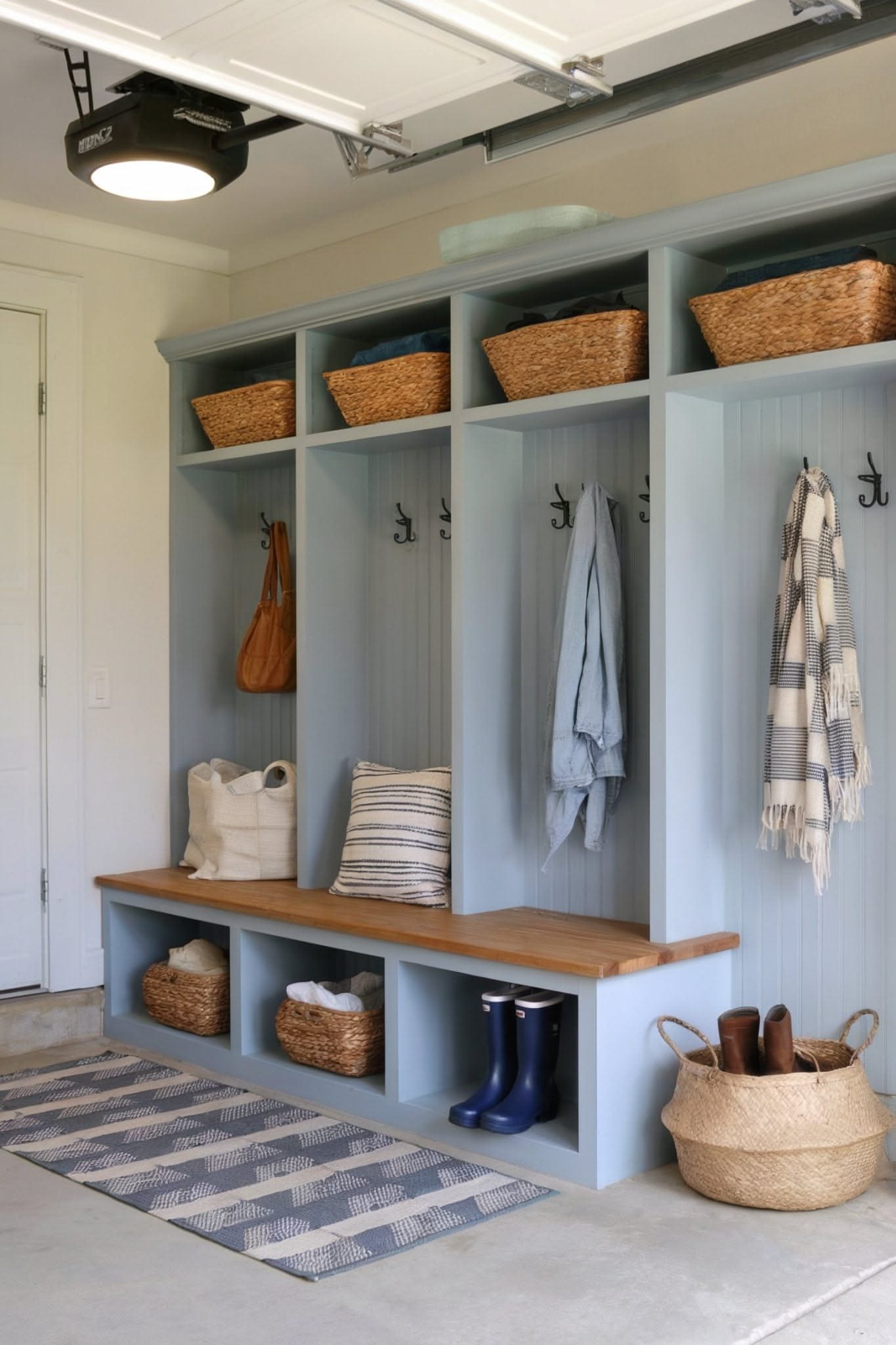Blue-gray built-in lockers in a garage with baskets on top and a striped rug