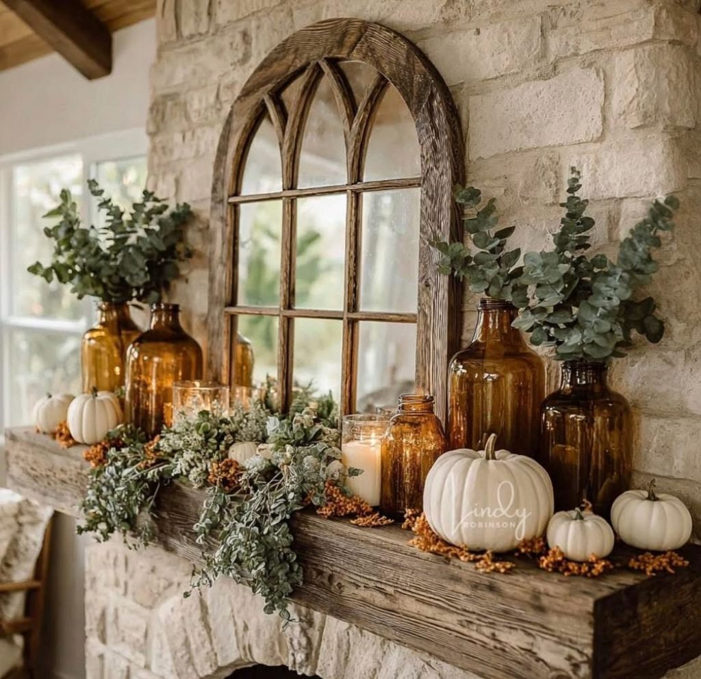 Cozy cottage-style fall mantel with layered pumpkins, candles and dried flowers