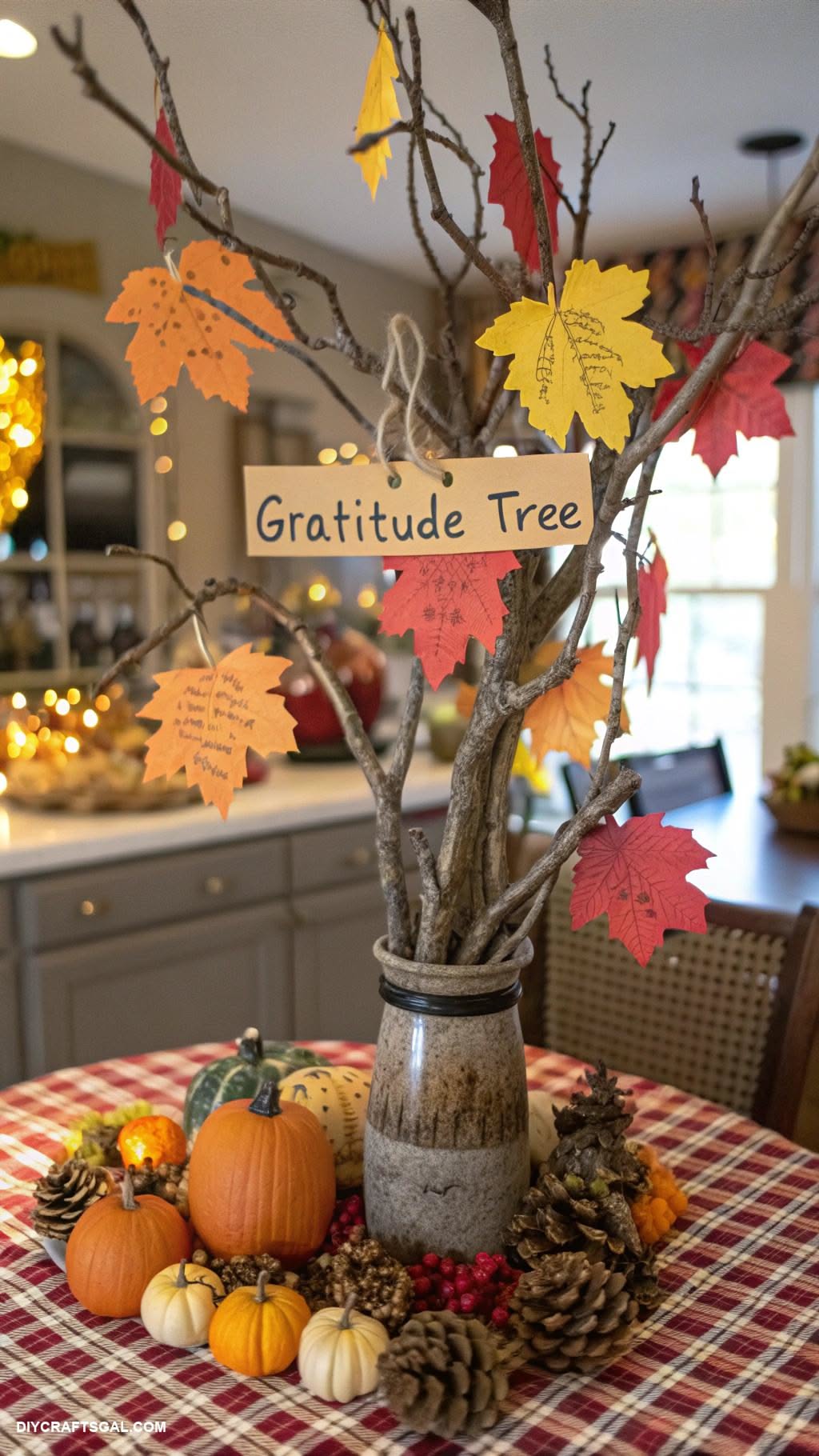 A gratitude tree centerpiece with paper leaf notes and a small pumpkin display
