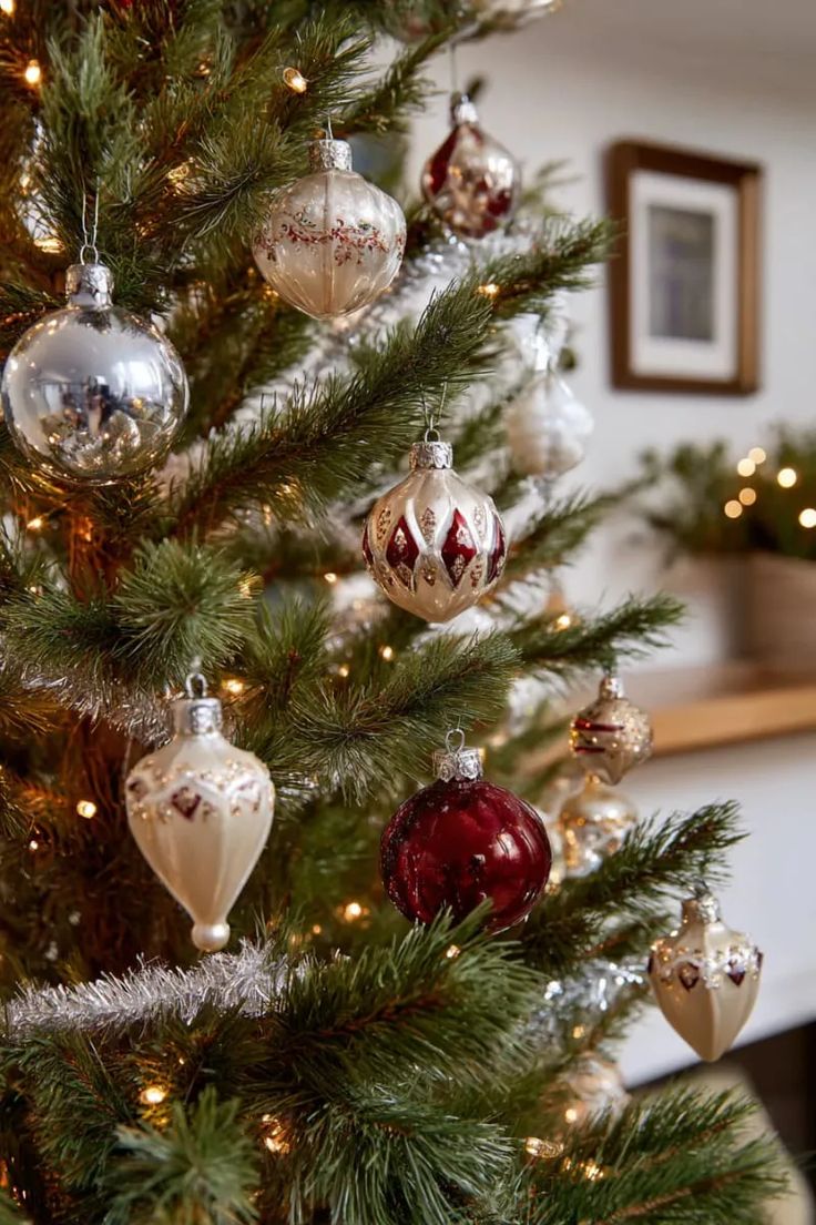 Christmas tree trimmed with vintage mercury glass ornaments in silver and cream