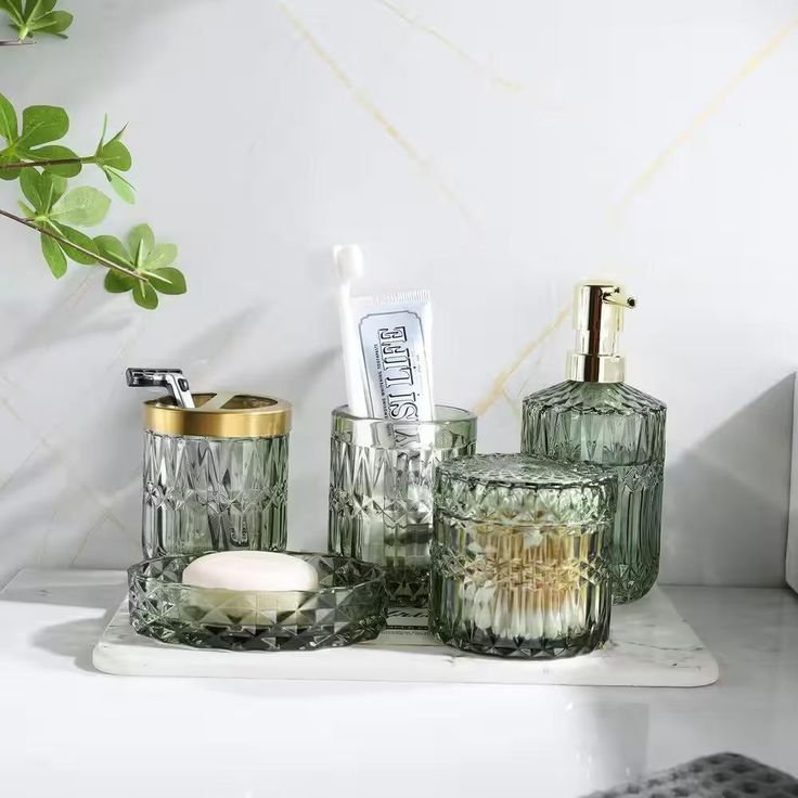 Green glass bathroom accessories including a soap dispenser and storage tray