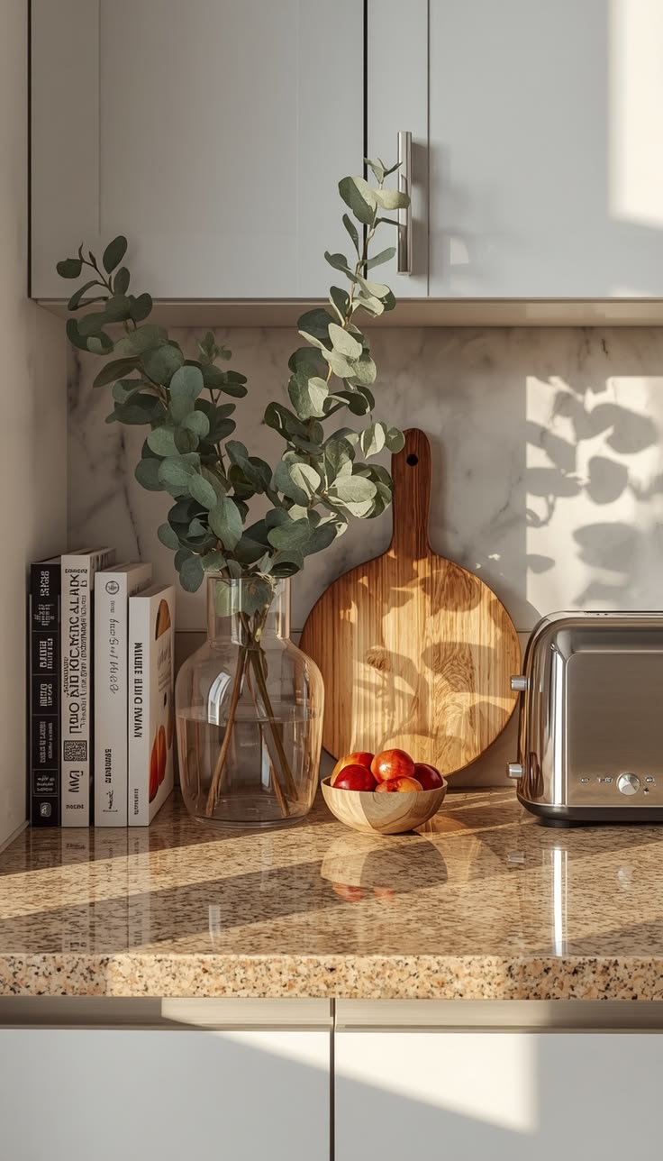 Small vase of greenery styled on a warm, earthy kitchen counter