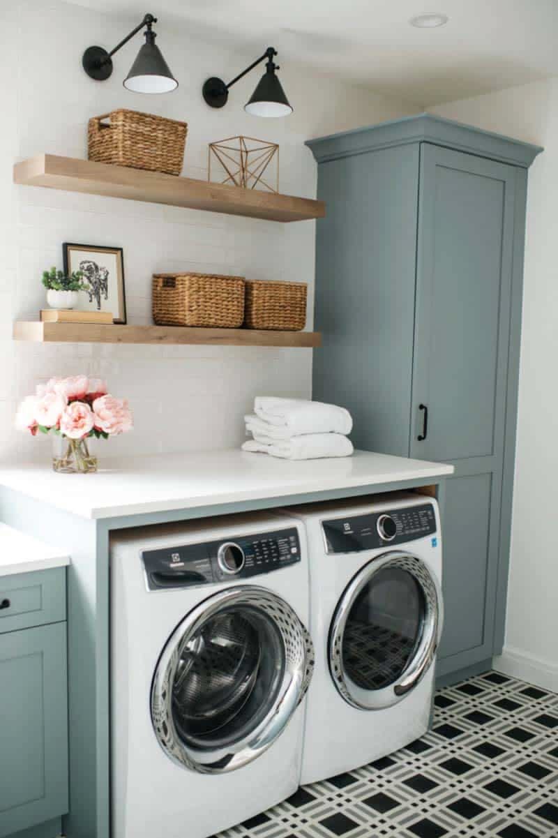 Blue-gray laundry room with a tall storage cabinet, black wall sconces and checkerboard tile floor