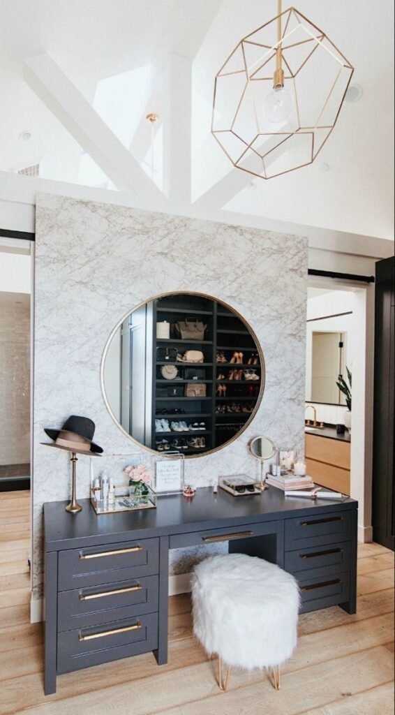 Statement makeup vanity with a bold marble finish and unique mirror shape