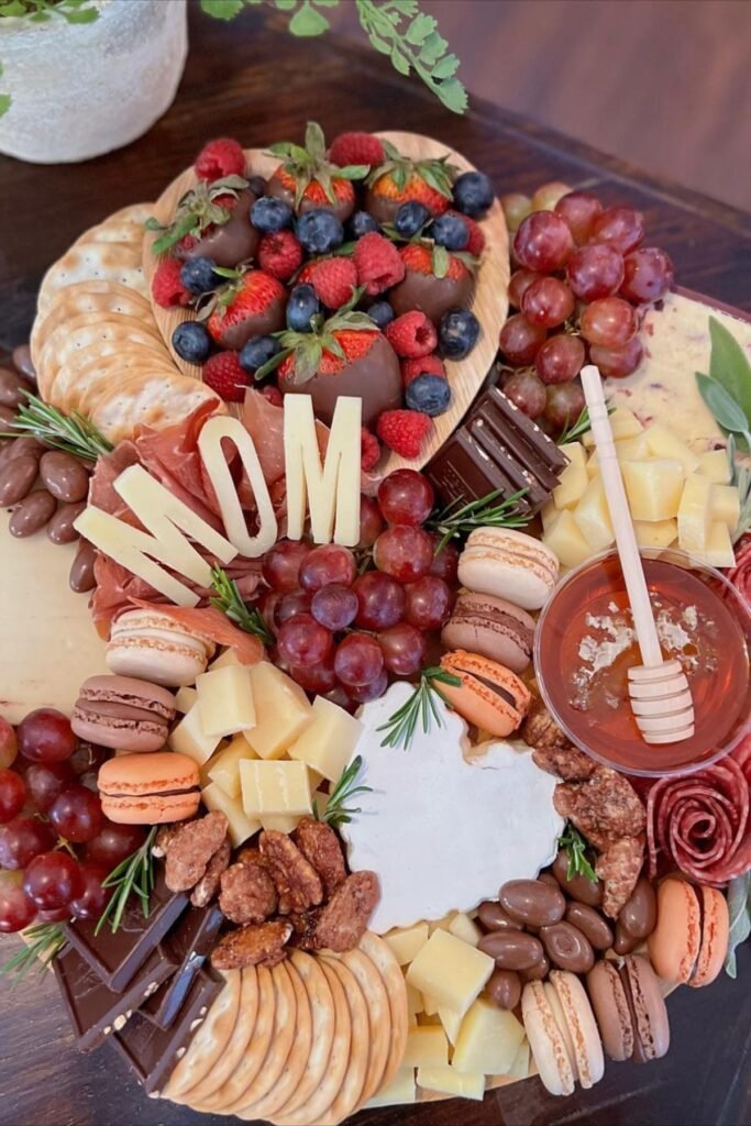 Floral-themed grazing board with soft pink and white cheeses, berries and edible flowers arranged around the edges