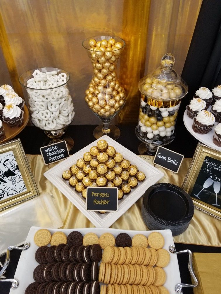 A gold and black dessert table with cupcakes, cookies, pretzels, and Ferrero Rocher chocolates