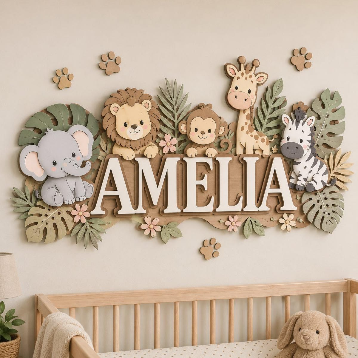 Wood name sign with animal cutouts spelling a baby's name above a nursery crib