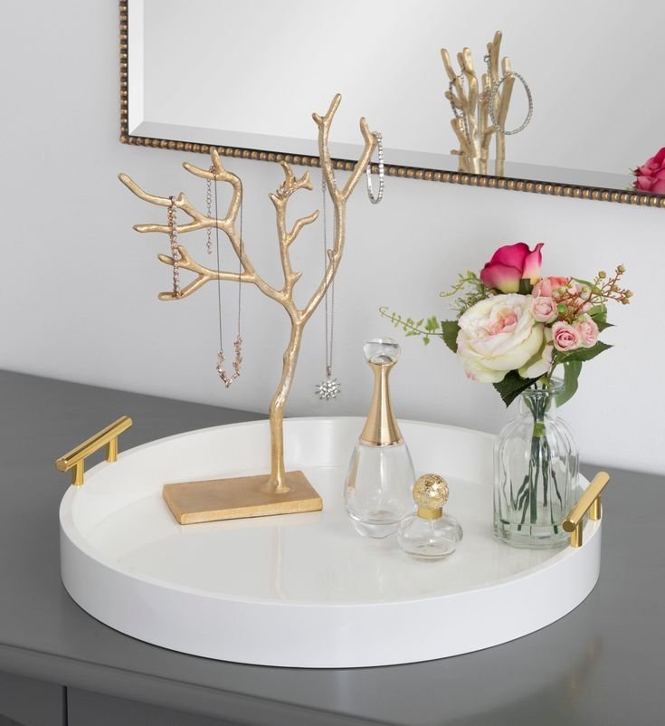 Round tray anchoring decor on a console table in a hallway