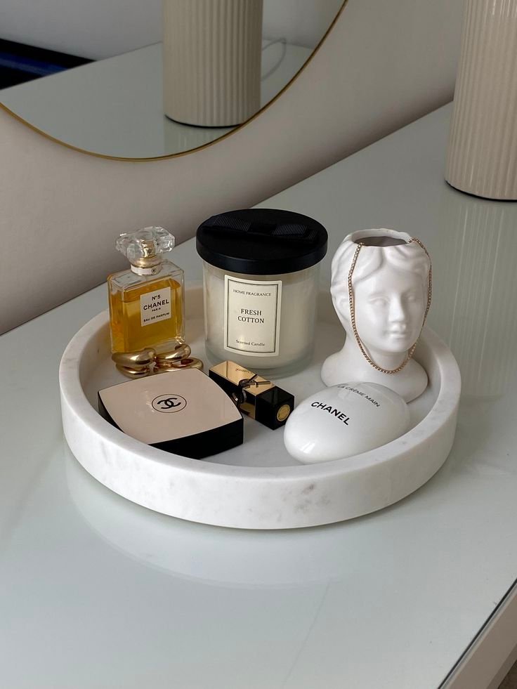 Round marble tray organizing perfume and jewelry on a vanity table