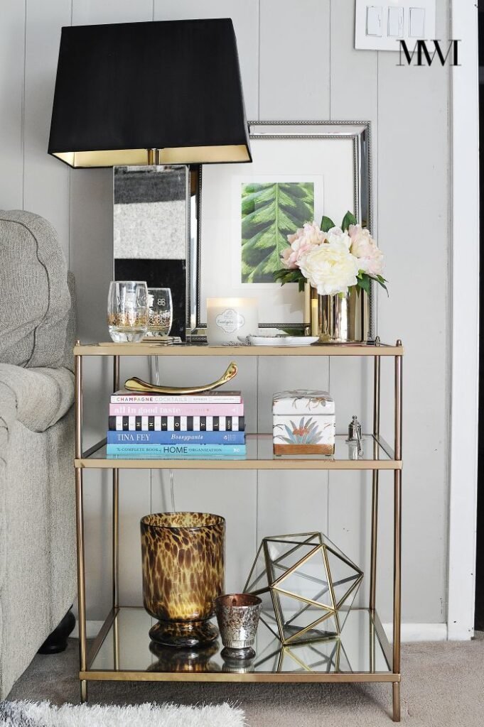 Layered textures styled across a tiered side table with books and candles