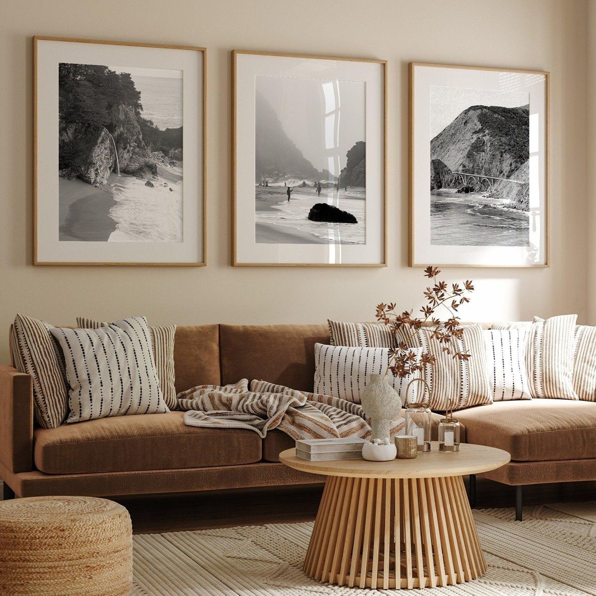 Black and white triptych of coastal photography hung above a sofa
