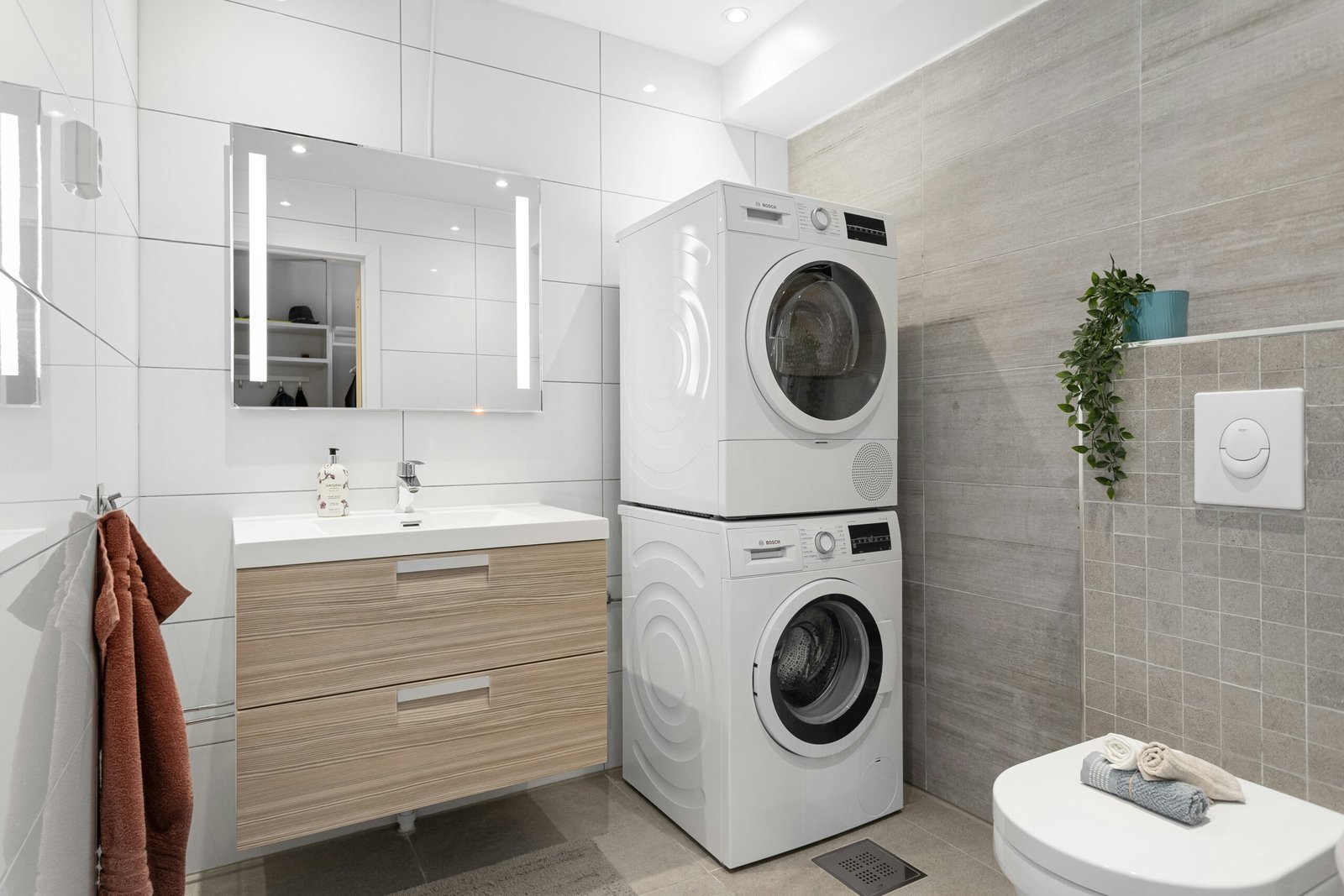 Stylish stacked washer and dryer laundry setup with smart storage