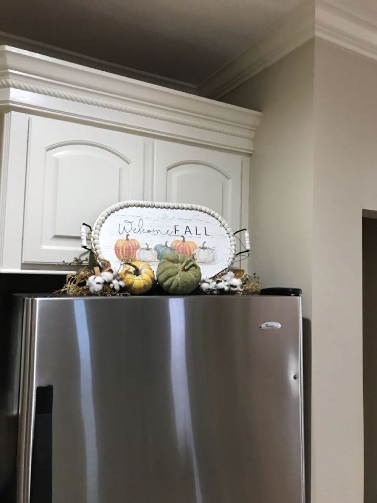 Fall-themed seasonal decor with pumpkins styled above a refrigerator