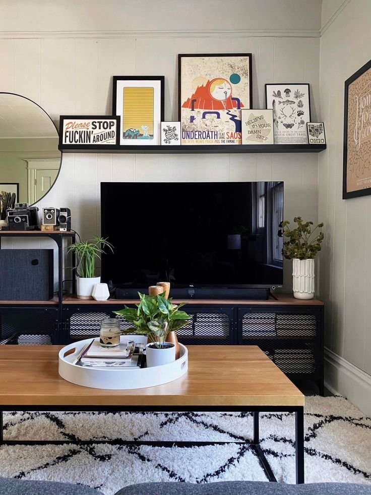 Art leaned casually against the wall near a TV stand