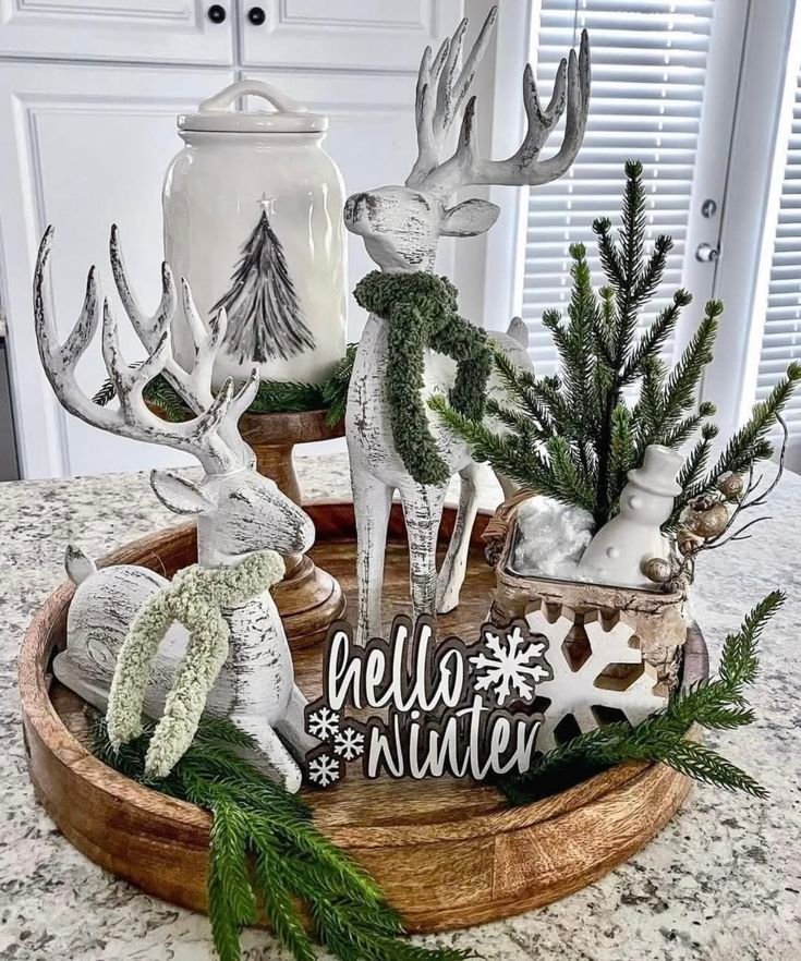 Wooden tray styled as a winter centerpiece with candles and greenery