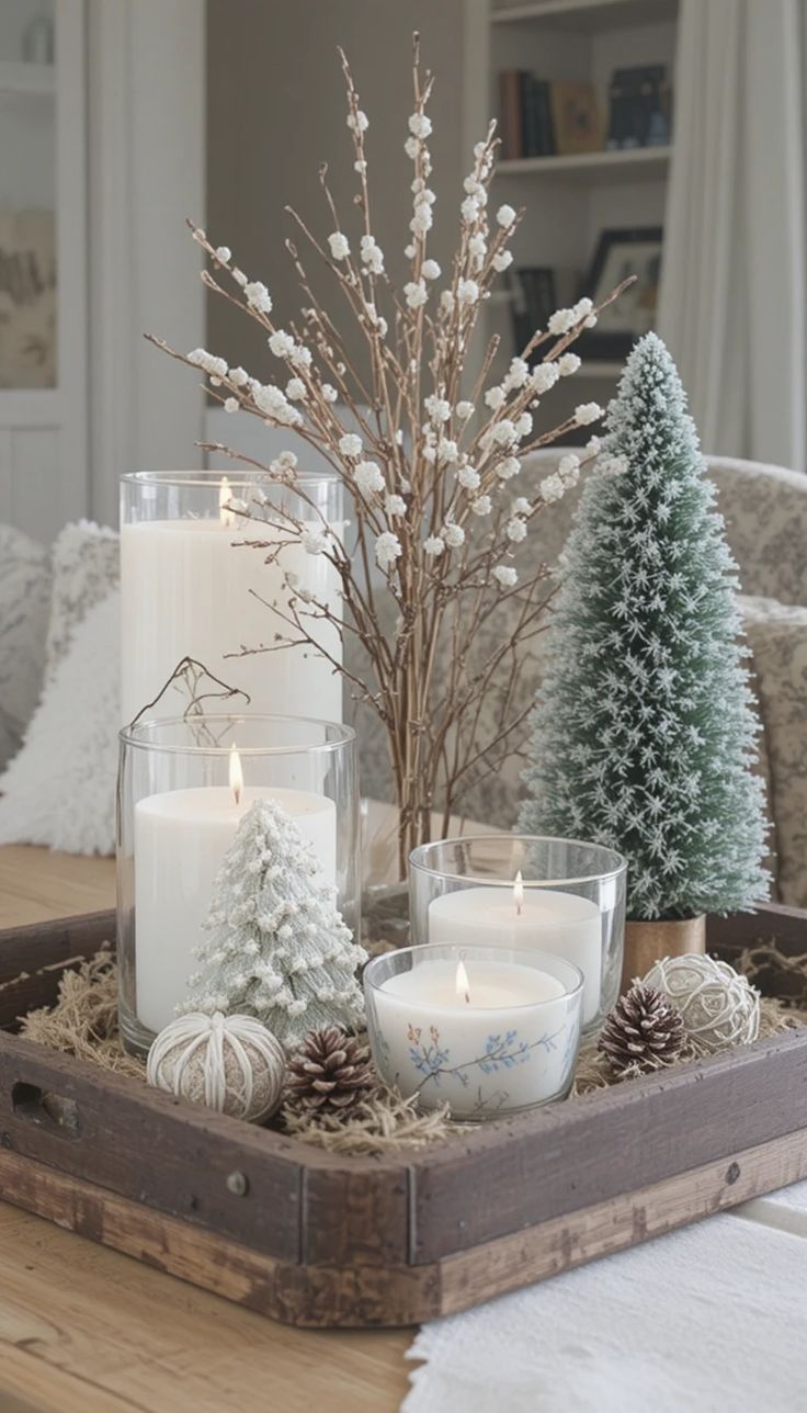 Rustic wood crate tray with tall glass hurricane candles, pale willow branches and frosted trees