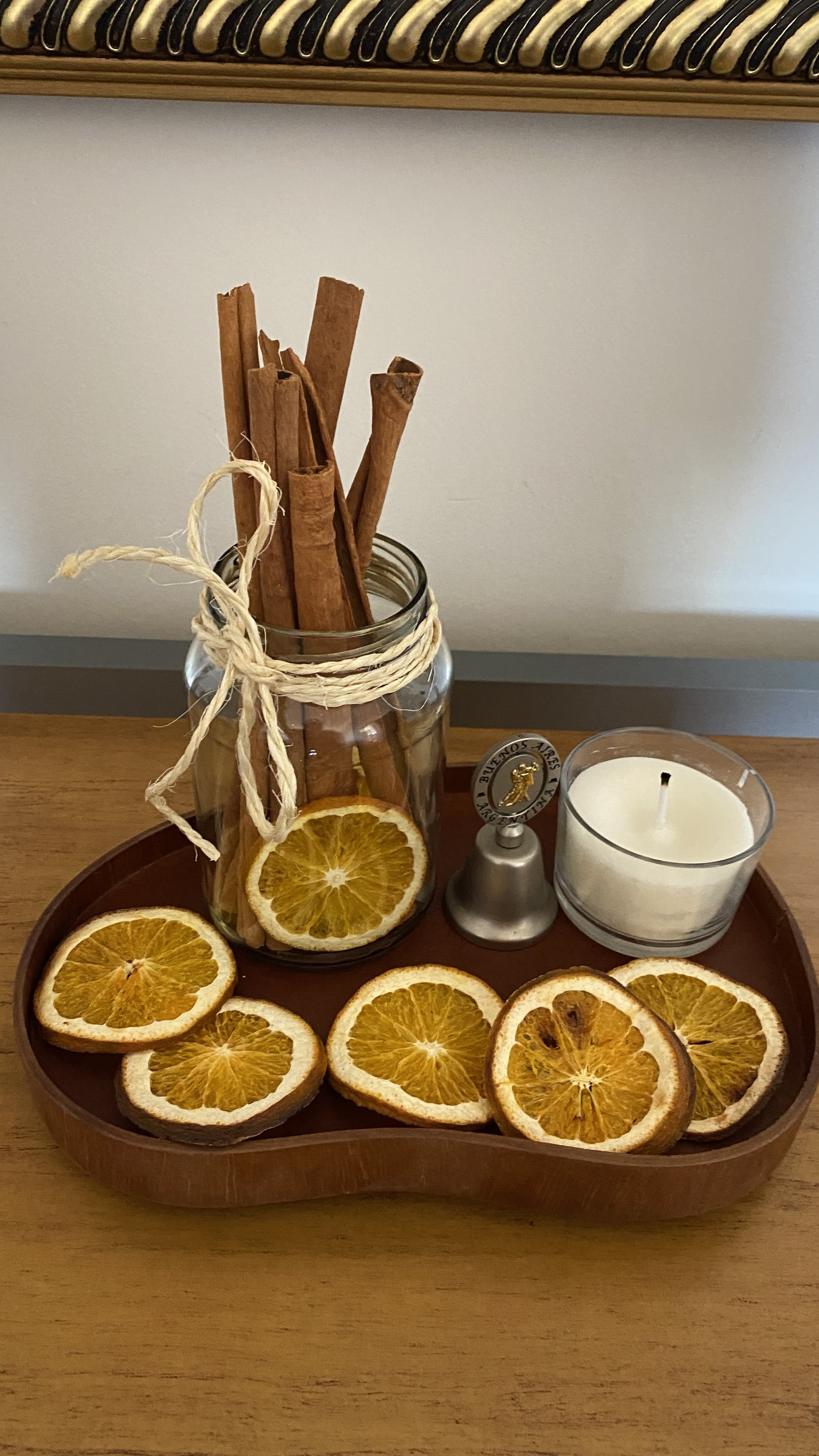 Wood slice tray with dried orange slices and a cinnamon bundle