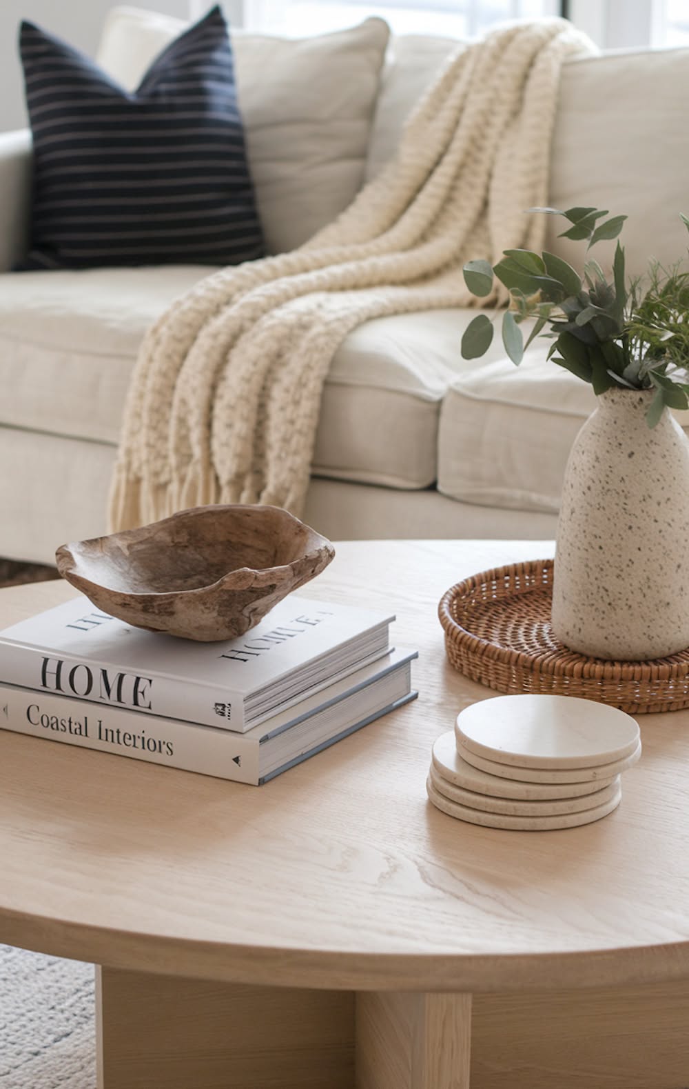 Round tray with stacked books and a large wood dough bowl