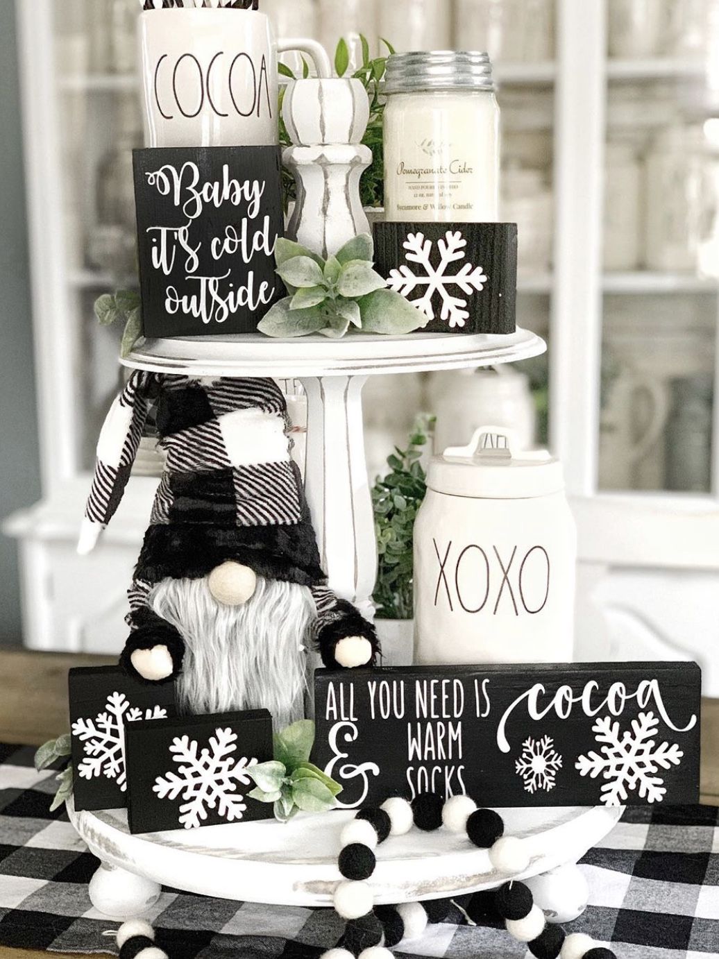 Black and white tiered tray with a plush gnome and snowflake sign