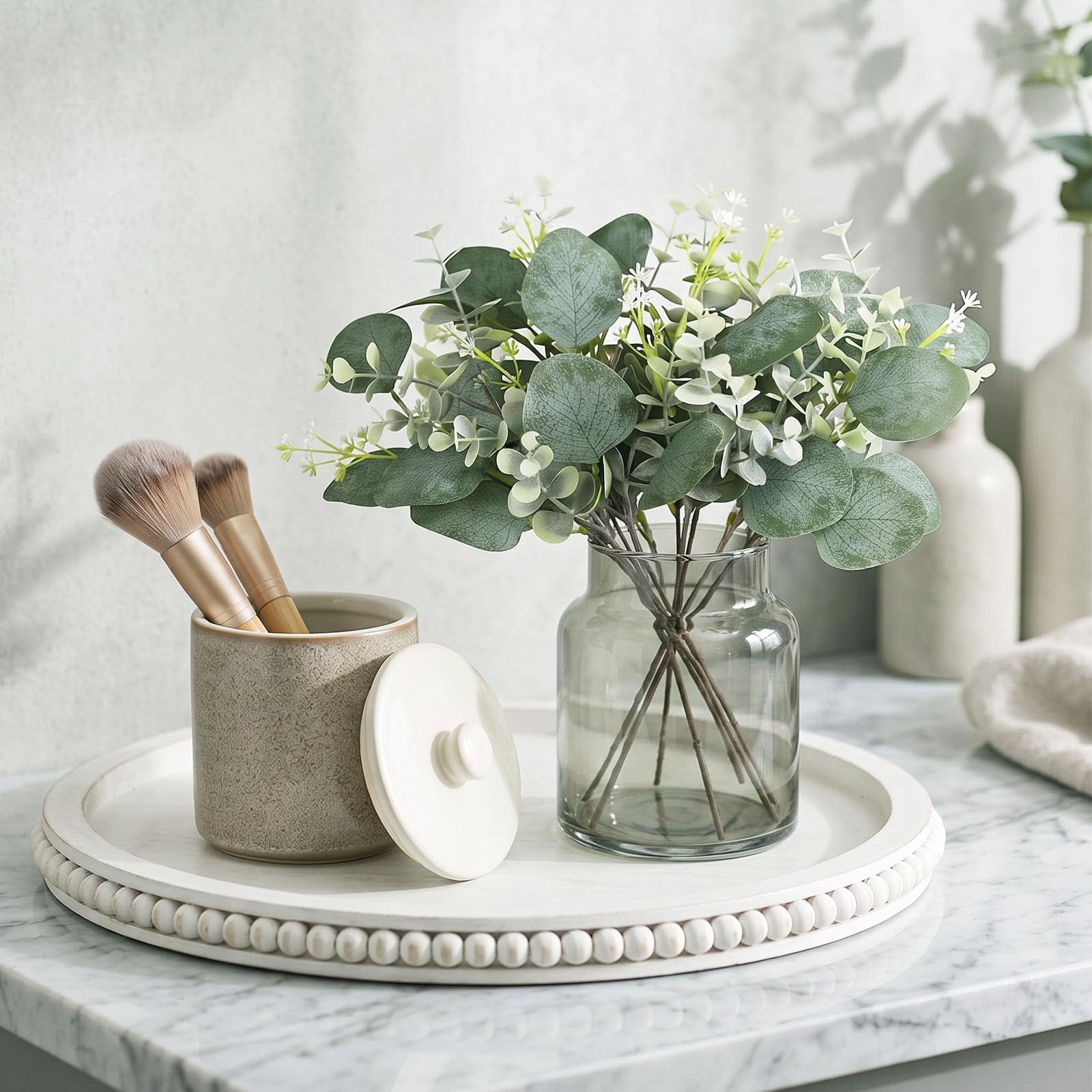 Vanity tray with eucalyptus stems and a lidded ceramic jar