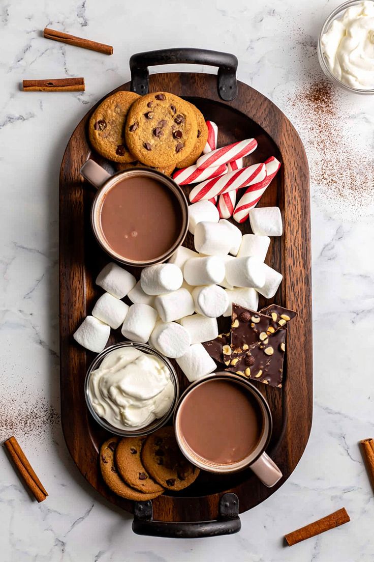 Tray with snowflake mugs of hot cocoa and a cinnamon stick bundle